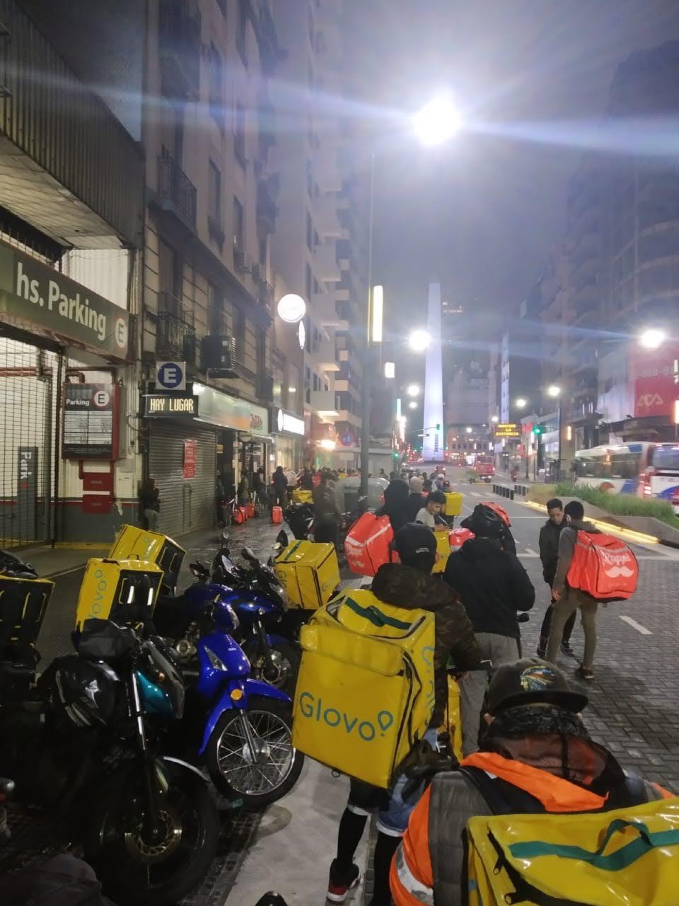 Repartidores esperando pedidos frente al Obelisco, Buenos Aires